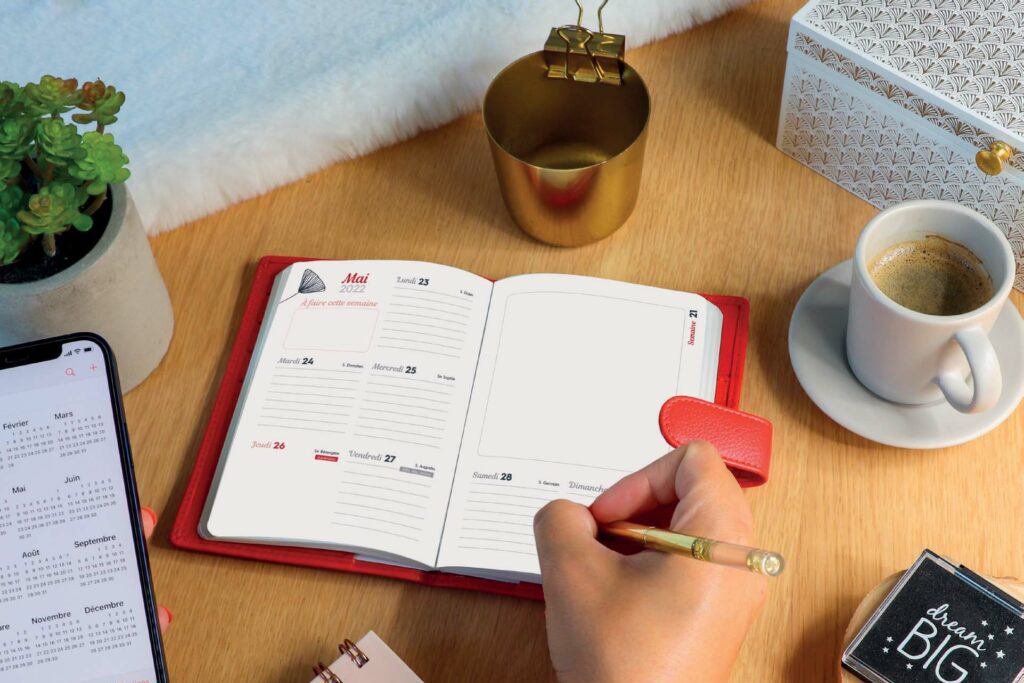 Photo d'un agenda notebook ouvert avec son porte-agenda rouge